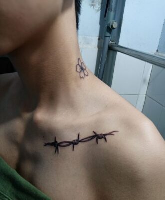 Hình xăm hoa và dây thép gai trên cổ và vai, phong cách blackwork, độ phân giải HD.