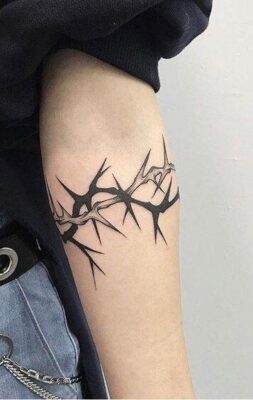 Hình xăm gai nhọn ở bắp tay, phong cách blackwork, chi tiết rõ nét, độ phân giải HD.