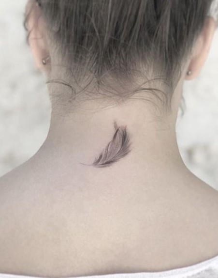 Hình xăm lông vũ mini ở gáy, phong cách blackwork tinh tế, ảnh độ phân giải HD.
