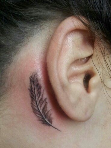 Hình xăm lông vũ mini sau tai, phong cách blackwork, chi tiết rõ nét, ảnh HD.