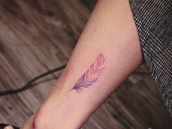 Hình xăm lông vũ màu nước trên chân, phong cách tinh tế, ảnh HD, chi tiết rõ nét.