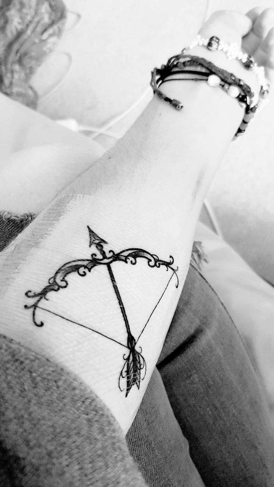 hình xăm mang tính cách mạnh mẽ Hình xăm cung tên phong cách blackwork trên cánh tay, chi tiết tinh tế, ảnh đen trắng chất lượng HD.