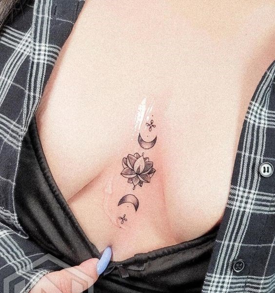 Hình xăm mini hoa sen và mặt trăng ở ngực, phong cách blackwork, chi tiết tinh tế, độ phân giải HD.