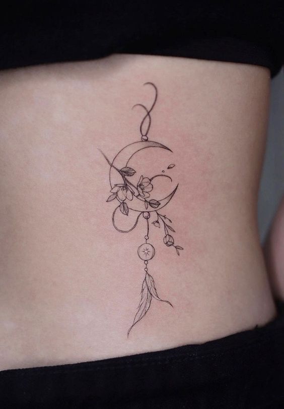 Hình xăm mặt trăng và hoa phong cách blackwork trên eo, chi tiết tinh tế, ảnh HD.
