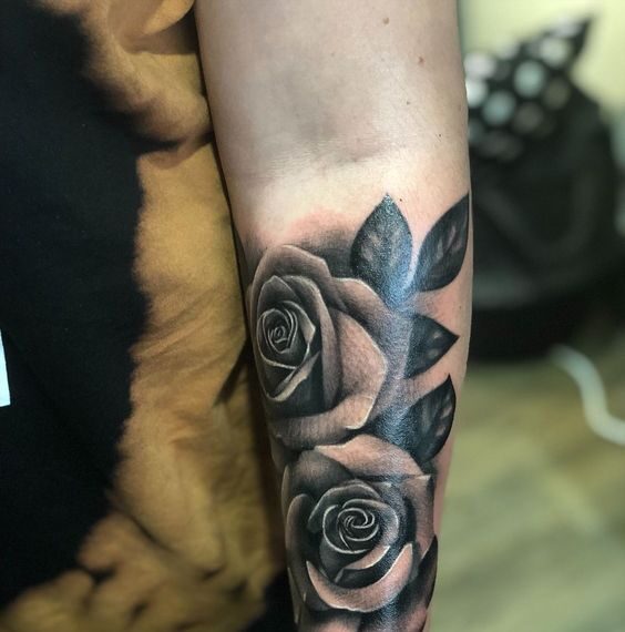Hình xăm hoa hồng, phong cách blackwork trên cánh tay, chi tiết rõ nét, độ phân giải HD.