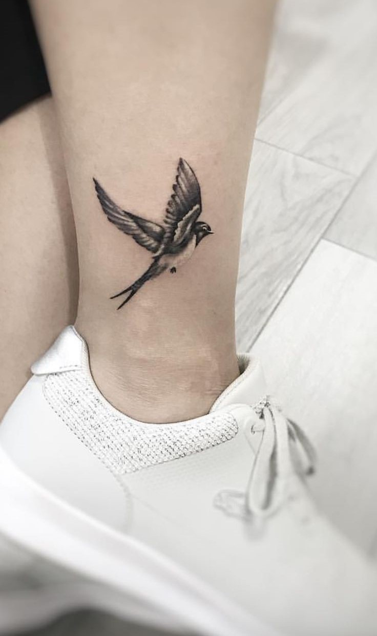 Hình xăm chim én ở mắt cá chân, phong cách blackwork, chi tiết rõ nét, độ phân giải HD.