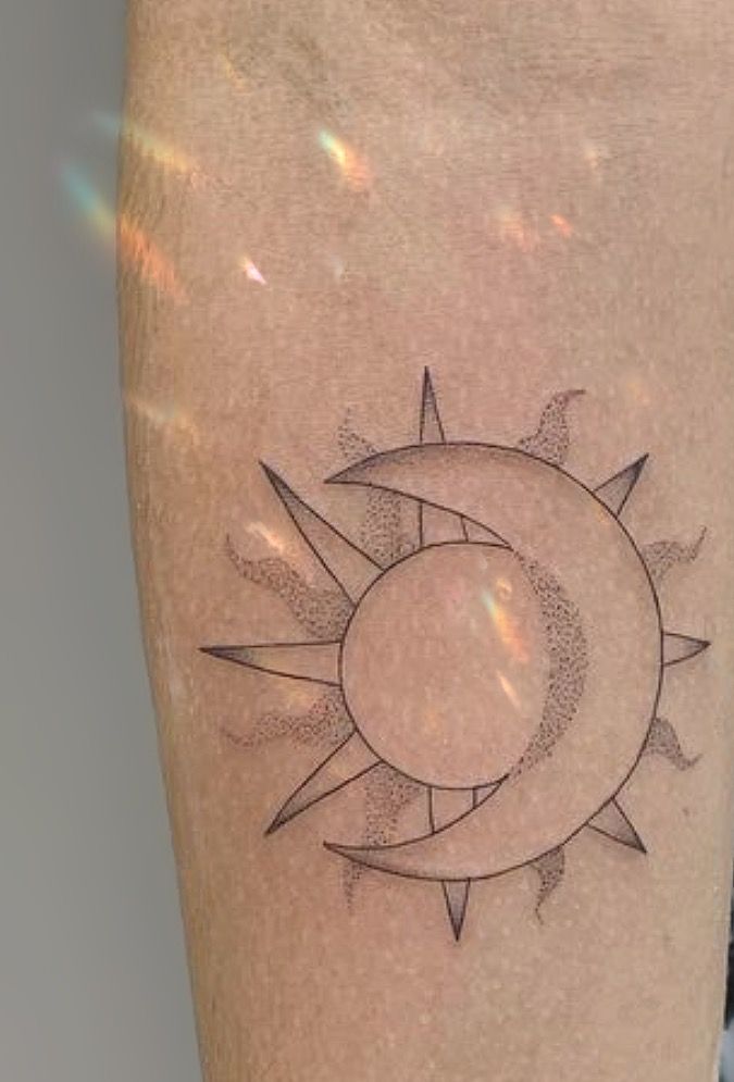 hình xăm mặt trăng ôm mặt trời Hình xăm mặt trời và mặt trăng trên bắp tay, phong cách blackwork, chi tiết rõ nét, độ phân giải HD.