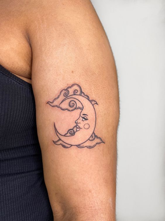 hình xăm mặt trăng sống động Hình xăm mặt trăng và mây trên bắp tay, phong cách blackwork, chi tiết rõ nét, ảnh HD.