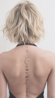 Hình xăm hoa văn tinh tế chạy dọc sống lưng, phong cách blackwork, ảnh độ phân giải cao.