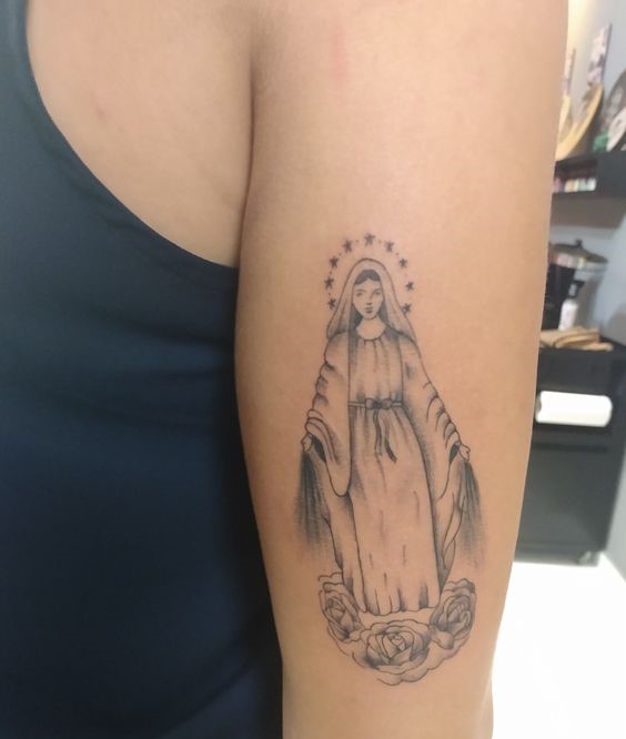 hình xăm nhỏ công giáo ở mặt tay Hình xăm Đức Mẹ trên cánh tay, phong cách blackwork, chi tiết tinh tế, độ phân giải HD.