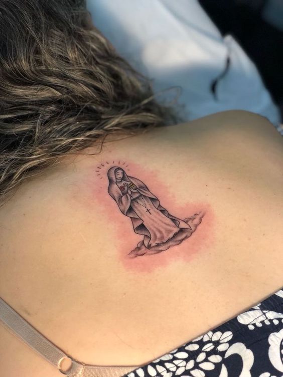 hình xăm nhỏ công giáo đầy ý nghĩa Hình xăm tôn giáo trên lưng, phong cách blackwork, chi tiết cao, độ phân giải HD.