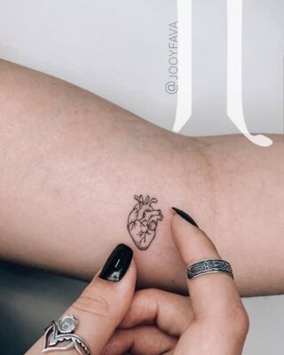 Hình xăm mini trái tim giải phẫu trên tay, phong cách blackwork, chi tiết tinh tế, ảnh HD.