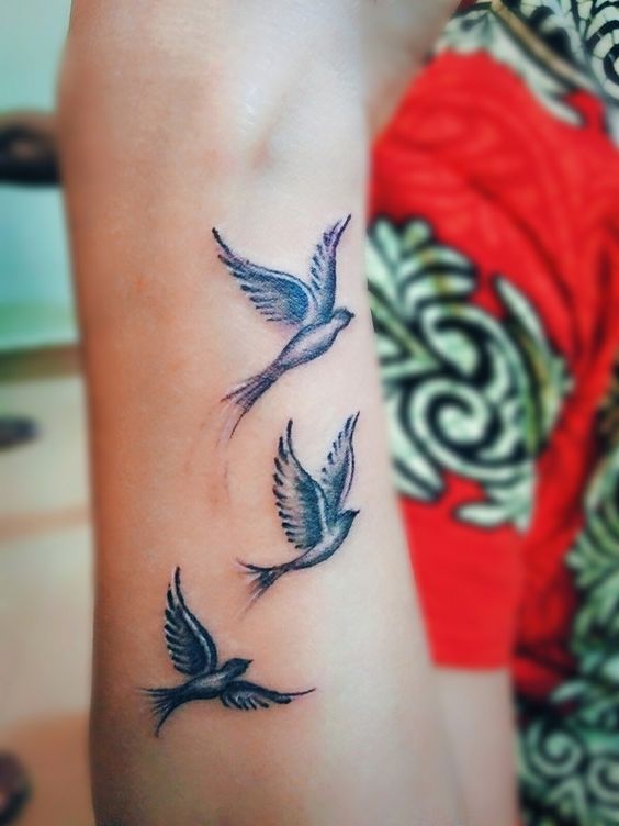 Hình xăm chim bay trên tay, phong cách blackwork, chi tiết tinh tế, độ phân giải HD.