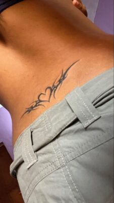 Hình xăm tribal tim trên lưng dưới, phong cách blackwork, chi tiết, ảnh HD.