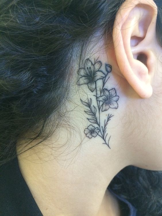 Hình xăm hoa phong cách blackwork sau tai, chi tiết tinh tế, ảnh chất lượng HD.