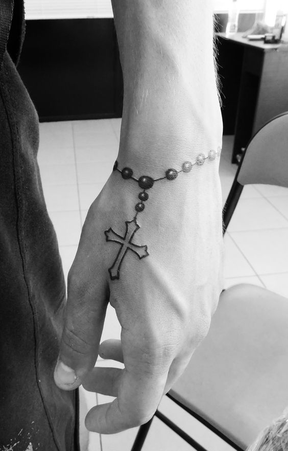 hình xăm mini vòng dây thánh giá Hình xăm chuỗi hạt thánh giá trên tay, phong cách blackwork, ảnh đen trắng rõ nét.