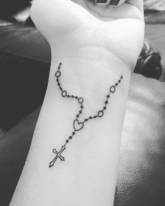 hình xăm mini vòng tay Công giáo Hình xăm chuỗi tràng hạt mini trên cổ tay, phong cách blackwork, ảnh đen trắng chi tiết, độ phân giải cao.
