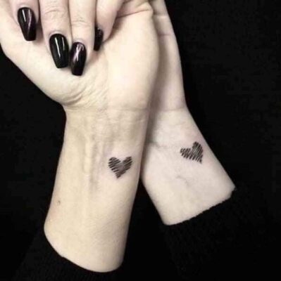 Hình xăm trái tim mini trên cổ tay, phong cách blackwork, độ phân giải HD.