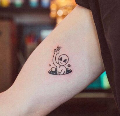 Hình xăm người ngoài hành tinh mini trên tay, phong cách blackwork, chi tiết, ảnh HD.
