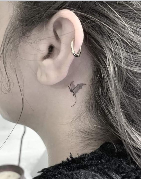 Hình xăm con dơi mini sau tai, phong cách blackwork, chi tiết sắc nét, ảnh HD.