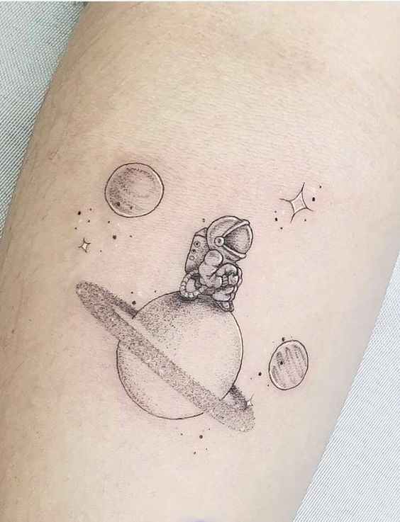 Hình xăm phi hành gia trên hành tinh, phong cách blackwork, vị trí trên tay, chi tiết tinh tế, độ phân giải HD.