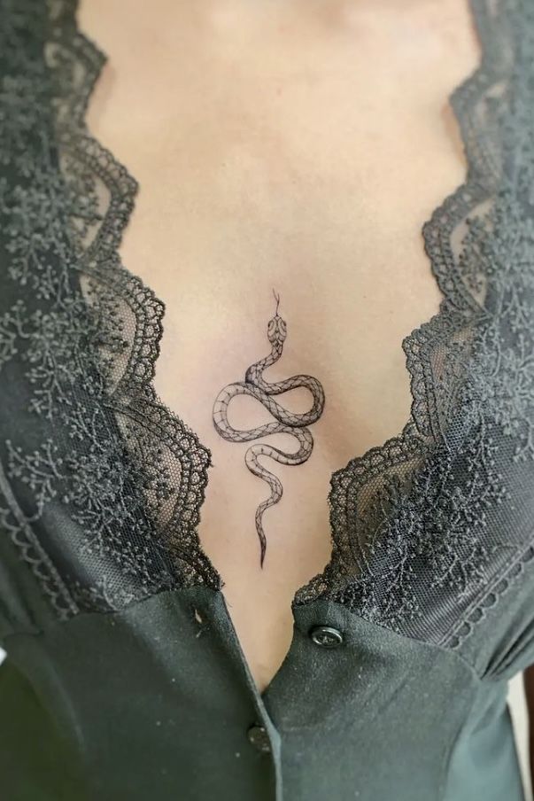 Hình xăm rắn nhỏ, phong cách blackwork, vị trí ngực, chi tiết tinh xảo, ảnh HD.