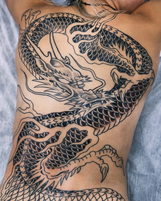 hình xăm rồng đơn sắc ở lưng của anh khách Hình xăm rồng lớn trên lưng, phong cách blackwork, chi tiết rõ nét, ảnh HD.