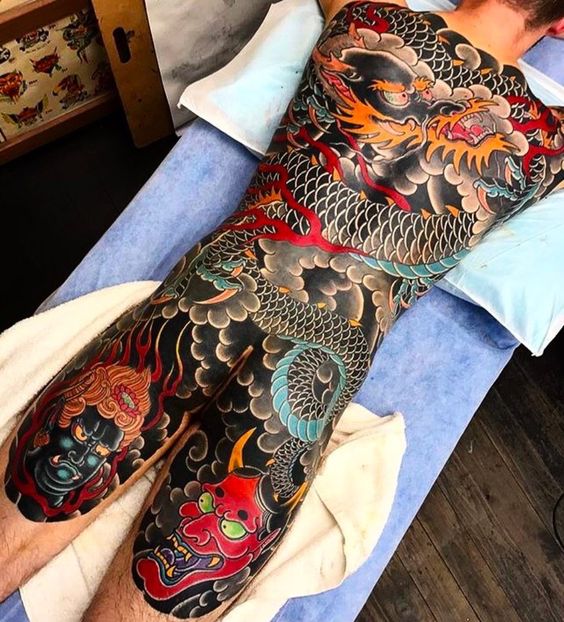 hình xăm rồng kết hợp mặt quỷ và mặt phật trải dài từ lưng xuống đùi Hình xăm rồng Nhật toàn thân, phong cách cổ điển, chi tiết, độ phân giải cao.