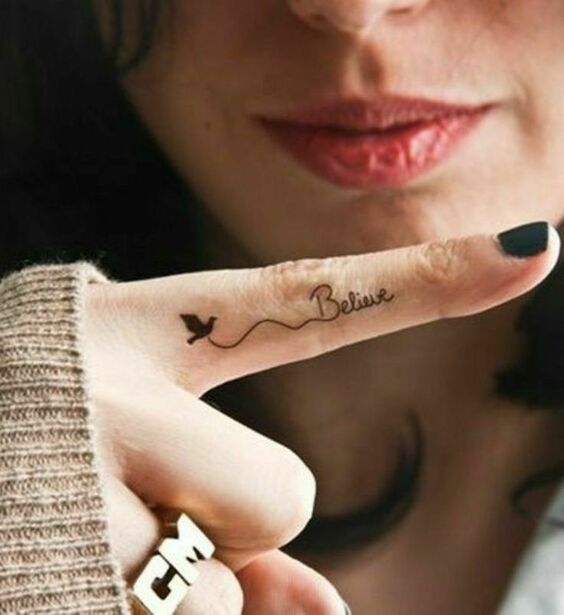 Hình xăm chữ "Believe" và chim mini trên ngón tay, phong cách tối giản, ảnh HD, chi tiết rõ nét.