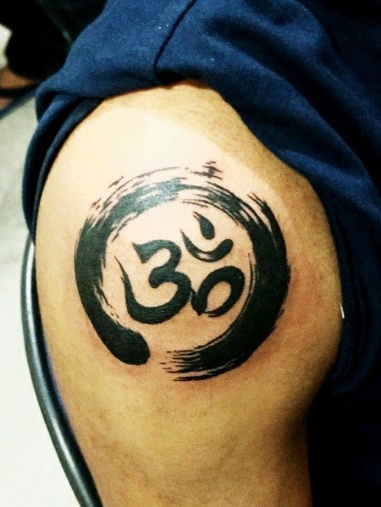 hình xăm toát lên vẻ đẹp của chàng trai Hình xăm biểu tượng Om trên vai, phong cách blackwork, chi tiết rõ nét, độ phân giải HD.