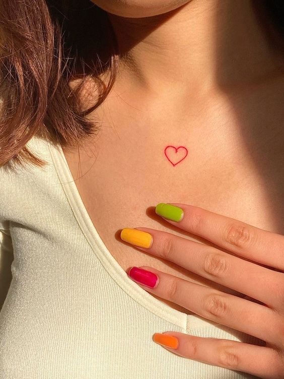tattoo trái tim đỏ nhỏ trước ngực Hình xăm mini trái tim đỏ trên ngực, phong cách tối giản, ảnh chất lượng HD.