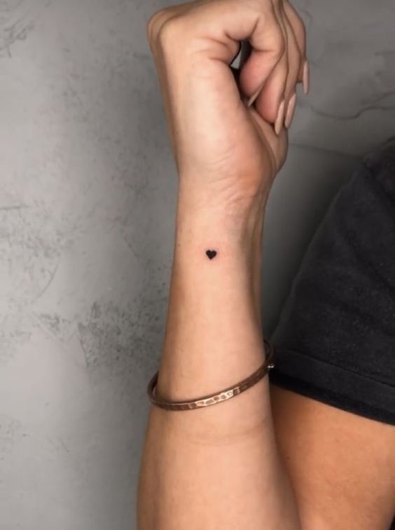 hình xăm trái tim siêu mini trên cổ tay Hình xăm trái tim mini trên cổ tay, phong cách blackwork, chi tiết đơn giản, ảnh HD.