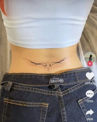 Hình xăm tribal ở lưng dưới, phong cách blackwork, chi tiết đơn giản, ảnh HD.