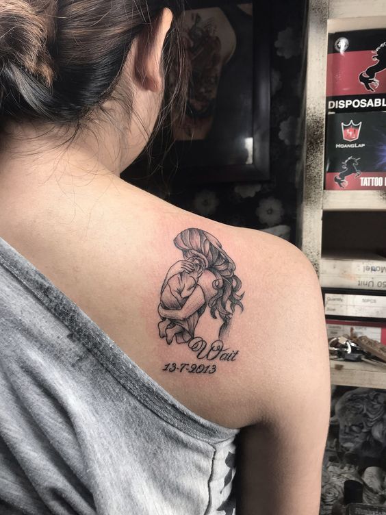 hình xăm mẹ cùng tên và sinh nhật của con Hình xăm mẹ và bé trên vai, phong cách blackwork, chi tiết rõ nét, độ phân giải HD.