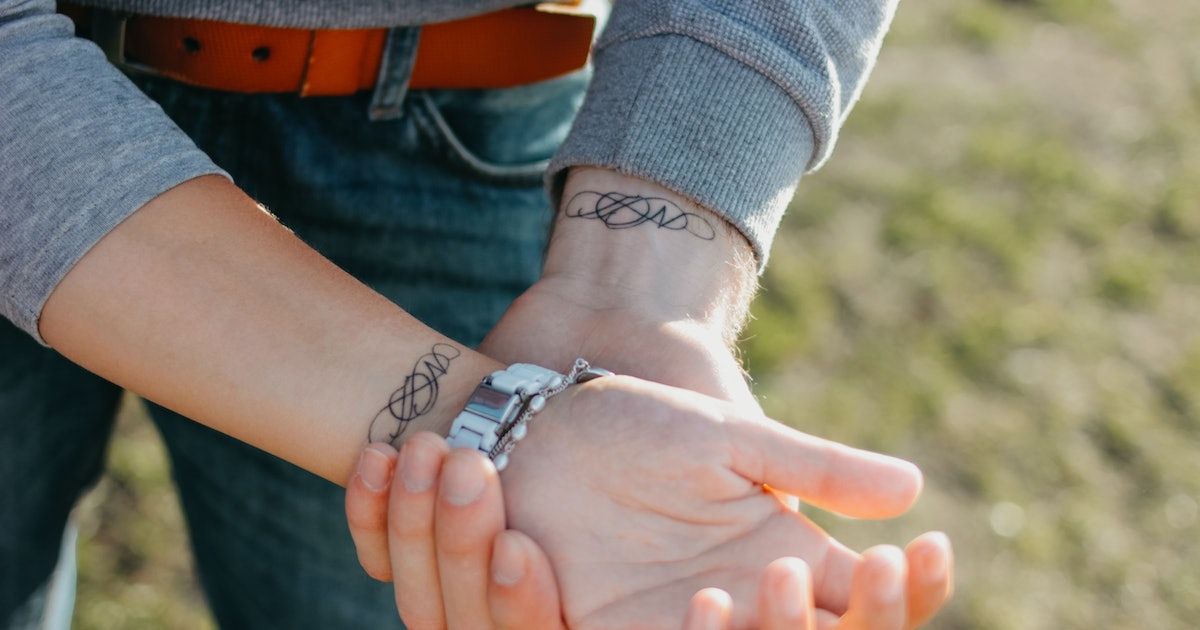 Hình xăm nét tối giản trên cổ tay, phong cách blackwork, ảnh HD.