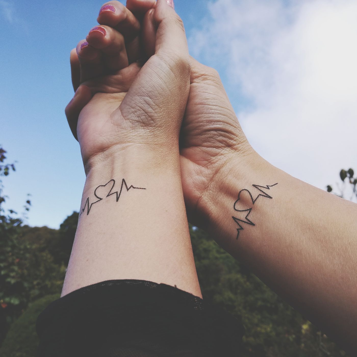 Hình xăm nhịp tim và trái tim trên cổ tay, phong cách blackwork, chi tiết rõ nét, ảnh HD.