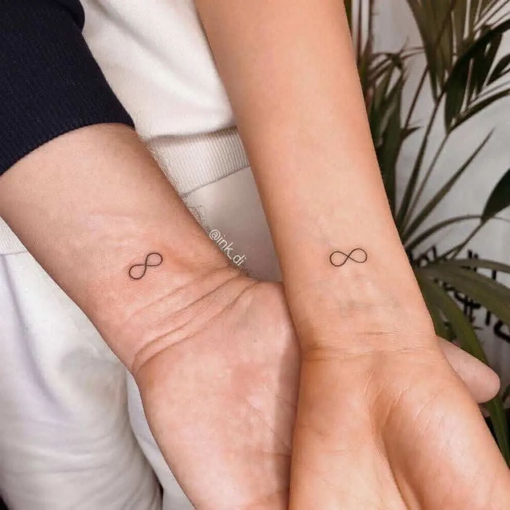 Hình xăm vô cực mini trên cổ tay, phong cách tối giản, ảnh độ phân giải cao, chi tiết rõ nét.