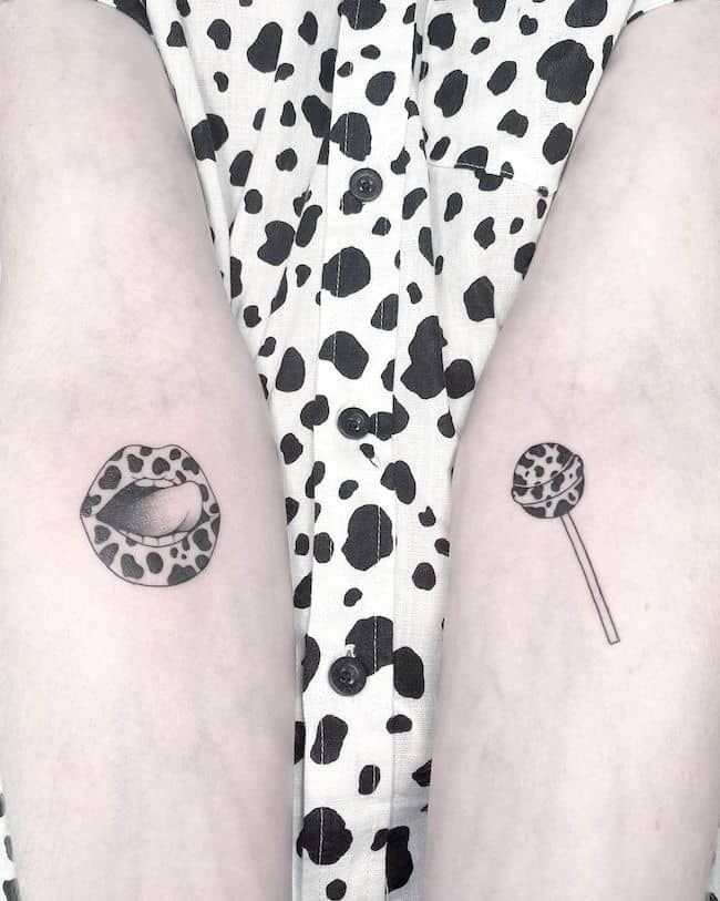 Hình xăm mini họa tiết môi và kẹo mút phong cách blackwork trên cánh tay, độ phân giải HD.