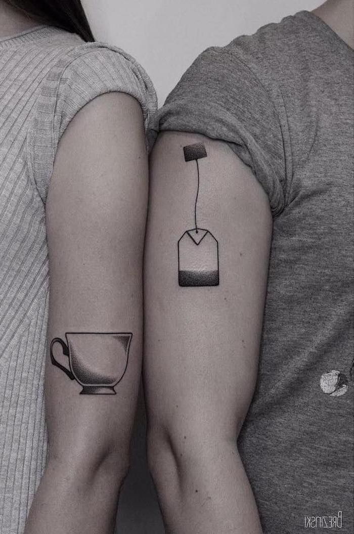 Hình xăm tách trà và túi trà trên cánh tay, phong cách blackwork, chi tiết rõ nét, độ phân giải HD.