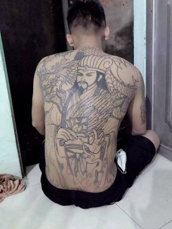 hoàn thiện hình xăm Khổng Minh cho khách Hình xăm nhân vật truyền thống trên lưng, phong cách blackwork, chi tiết sắc nét, độ phân giải HD.