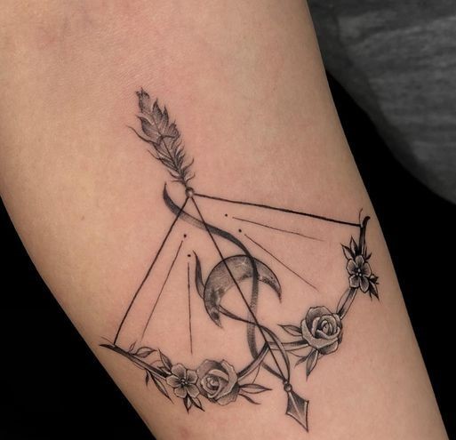 sự hòa quyện giữa cung tên và hoa hồng Hình xăm cung tên phong cách blackwork trên tay, chi tiết hoa và mặt trăng, độ phân giải HD.