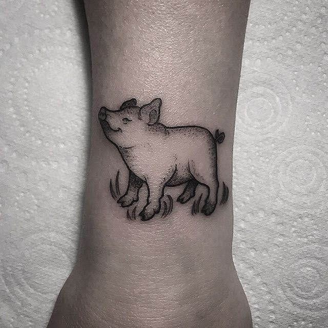tattoo heo đem lại thịnh vượng và may mắn Hình xăm con lợn mini trên cổ tay, phong cách blackwork, chi tiết rõ nét, độ phân giải cao.