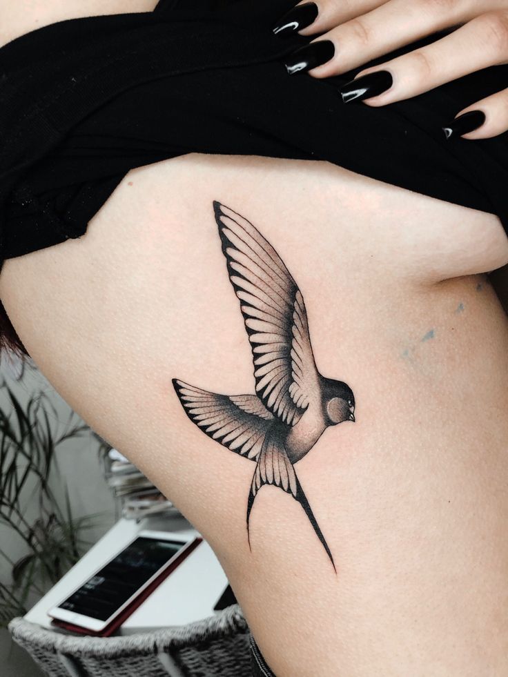 Hình xăm chim én ở sườn, phong cách blackwork chi tiết, ảnh HD rõ nét.