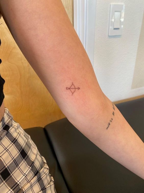 tattoo cung tên rất nhỏ Hình xăm cung tên mini trên cánh tay, phong cách blackwork, chi tiết đơn giản, độ phân giải HD.