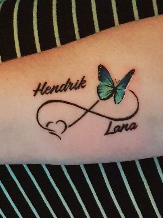 kiểu tatoo biểu đạt tình yêu bất diệt Hình xăm vô cực với bướm màu xanh trên tay, phong cách tối giản, độ phân giải HD.