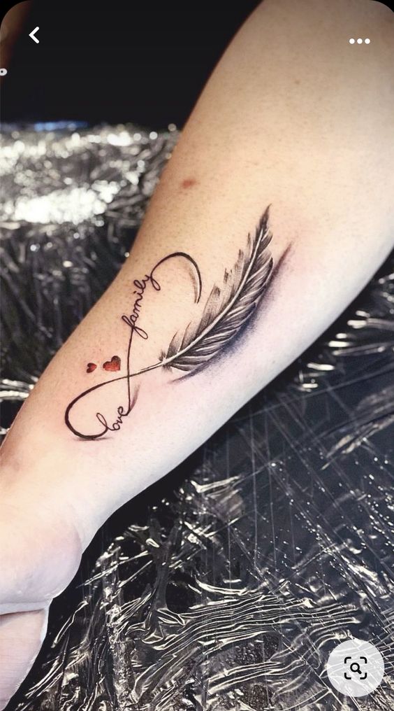 xu hướng tatoo nổi bật mới Hình xăm lông vũ và chữ "love" trên cánh tay, phong cách blackwork. Độ chi tiết cao, ảnh HD.