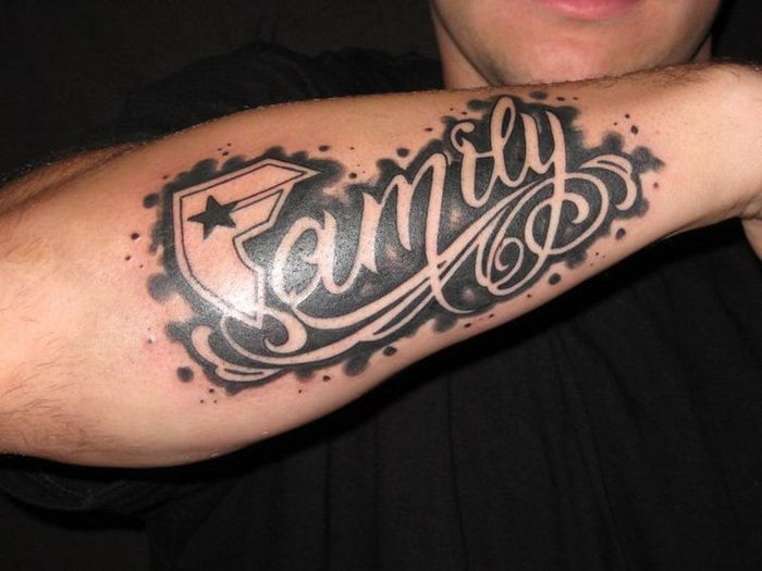 Hình xăm chữ "Family" trên cánh tay, phong cách blackwork, chi tiết rõ nét, độ phân giải HD.