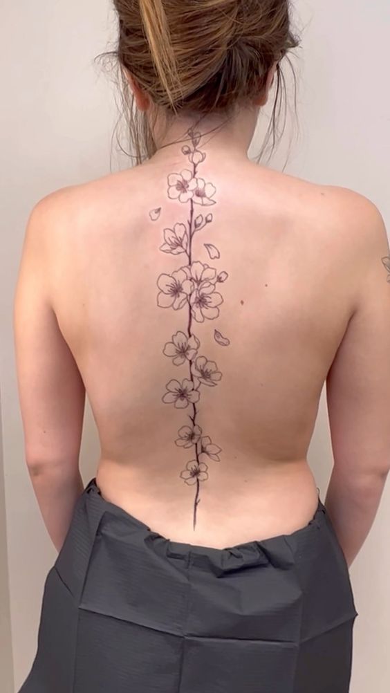 Hình xăm hoa trên lưng, phong cách blackwork, chi tiết tinh tế, độ phân giải HD.