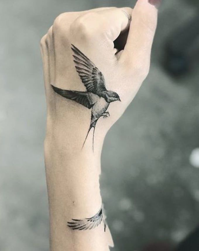Hình xăm chim én trên cổ tay, phong cách blackwork, chi tiết rõ nét, độ phân giải HD.