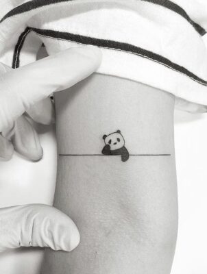 Hình xăm mini gấu trúc phong cách blackwork trên cánh tay, chi tiết đơn giản, ảnh HD.